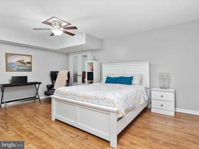 bedroom featuring baseboards, light wood-style flooring, and a ceiling fan