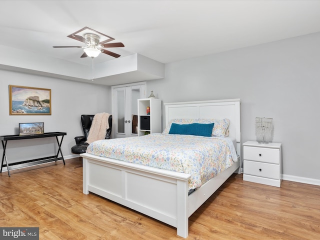 bedroom featuring baseboards, light wood-style floors, and a ceiling fan