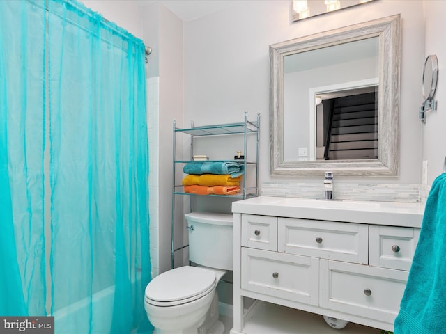 bathroom featuring toilet, vanity, tasteful backsplash, and a shower with shower curtain