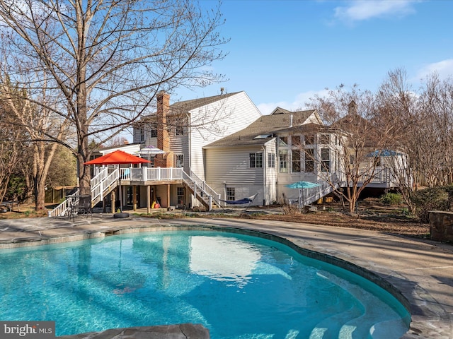 outdoor pool featuring stairway, a deck, and a patio