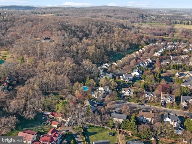 drone / aerial view featuring a residential view and a view of trees