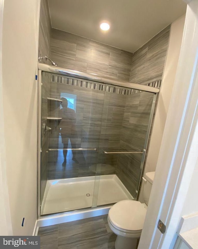 bathroom with a stall shower and toilet