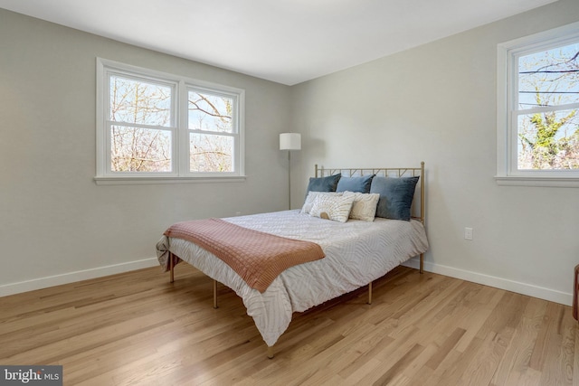 bedroom with light wood-style flooring and baseboards