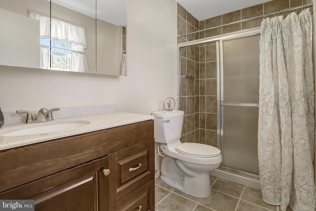 full bath featuring tiled shower, toilet, vanity, and tile patterned flooring