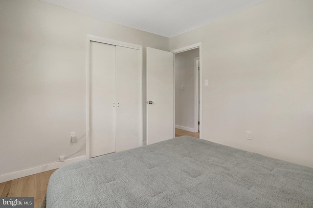 bedroom featuring a closet, baseboards, and wood finished floors