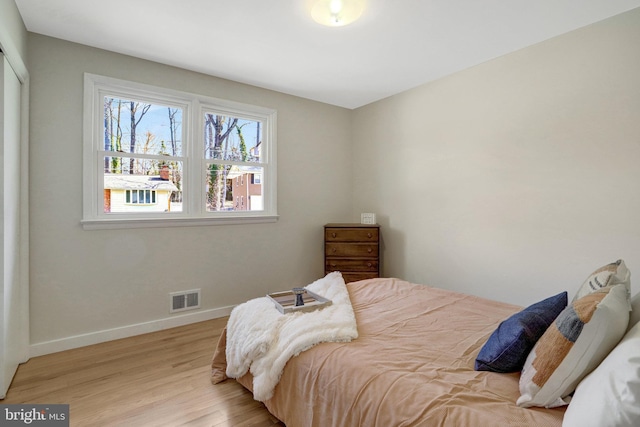 bedroom featuring wood finished floors, visible vents, and baseboards