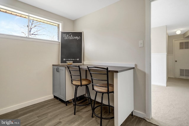 office with wood finished floors, visible vents, and baseboards