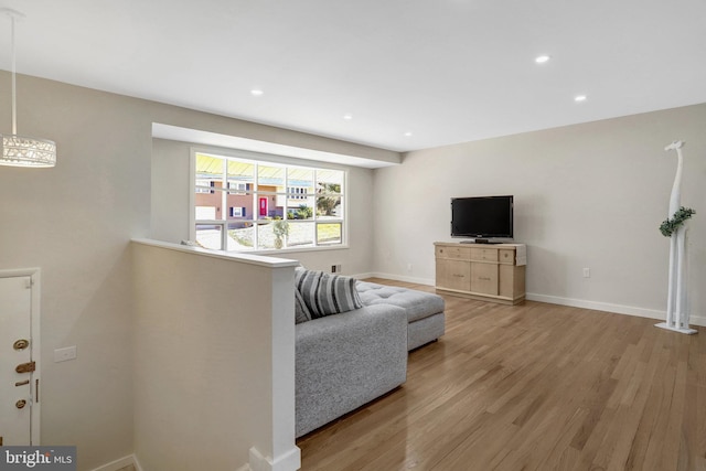 living room featuring recessed lighting, baseboards, and light wood-style floors