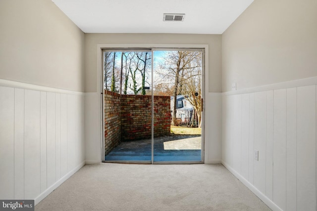 interior space with wainscoting, visible vents, and carpet flooring