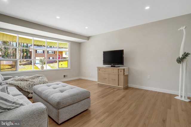 living room featuring recessed lighting, visible vents, baseboards, and light wood finished floors