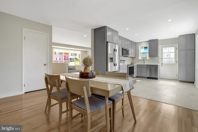 dining space with recessed lighting, a healthy amount of sunlight, and light wood-type flooring