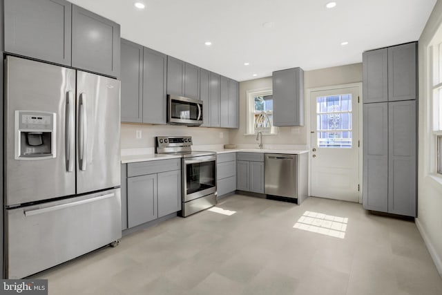 kitchen with light countertops, gray cabinetry, recessed lighting, and stainless steel appliances