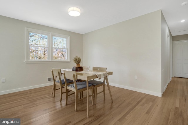 dining room with baseboards and light wood finished floors