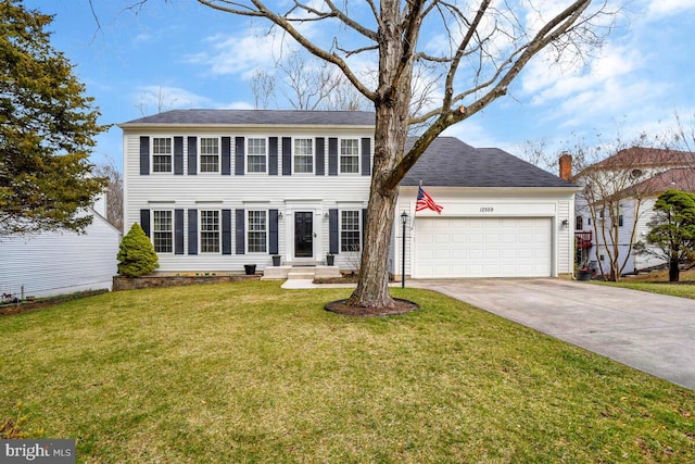 colonial house with a front yard, an attached garage, and driveway