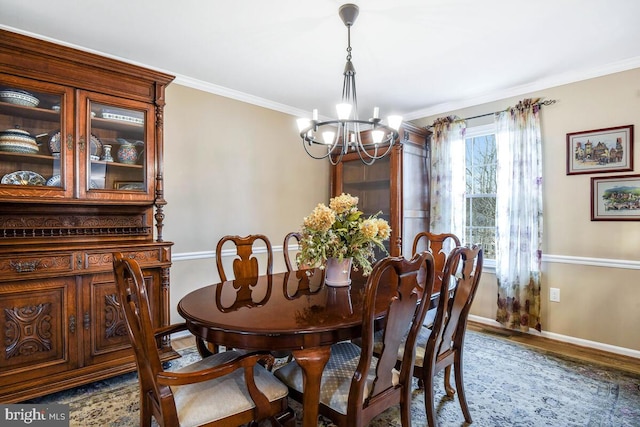 dining space featuring wood finished floors, visible vents, baseboards, ornamental molding, and a chandelier