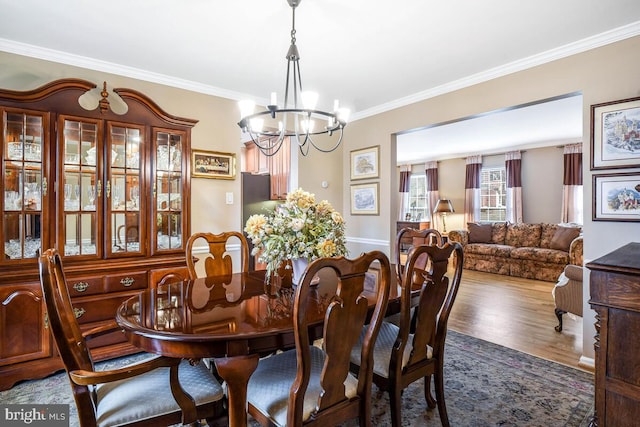 dining room featuring crown molding, a notable chandelier, and wood finished floors