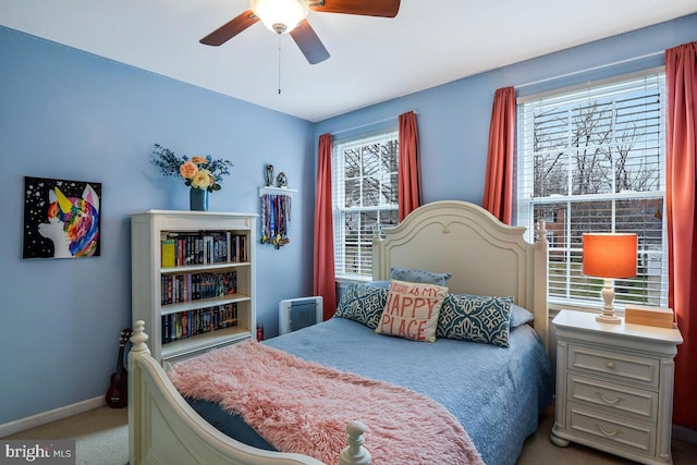 carpeted bedroom featuring baseboards and ceiling fan