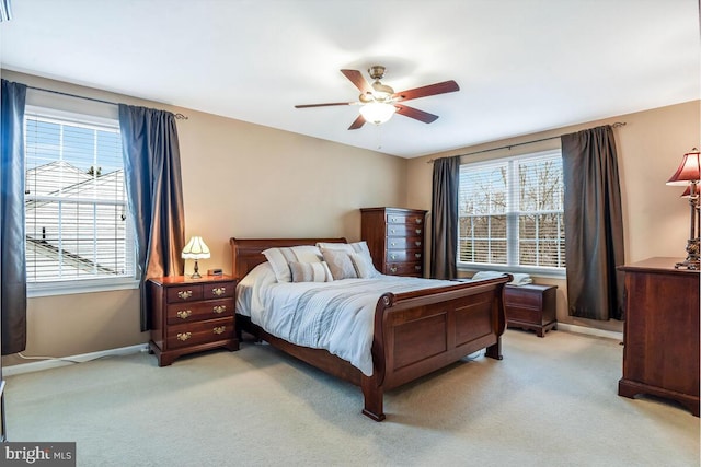 bedroom featuring light carpet, multiple windows, and baseboards