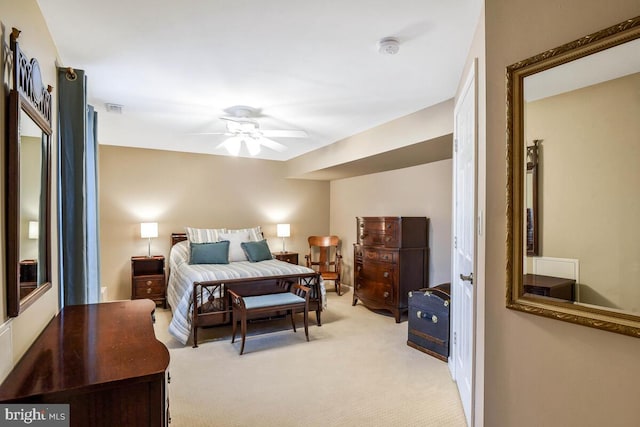 bedroom with visible vents, light colored carpet, and a ceiling fan