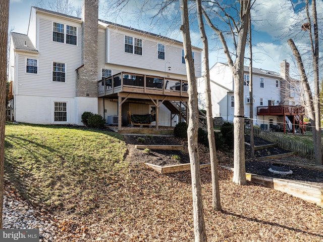 rear view of house featuring brick siding, fence, a wooden deck, central AC unit, and a yard