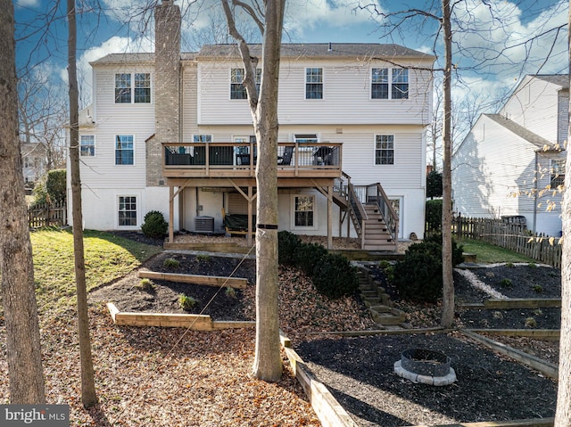 back of house featuring fence, stairway, a wooden deck, central AC, and a garden