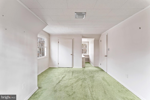 interior space with baseboards, carpet, and crown molding