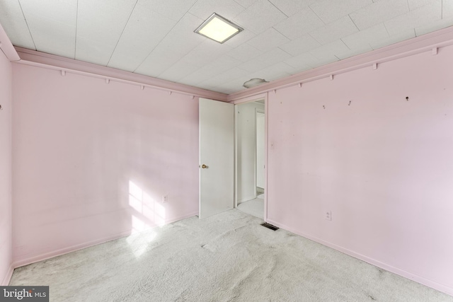 carpeted spare room featuring visible vents and baseboards