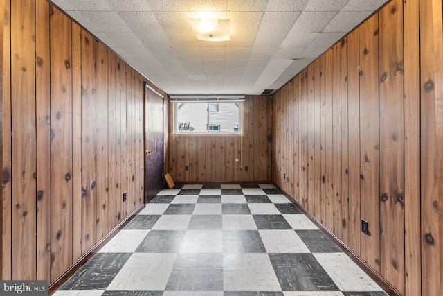 spare room with wooden walls and dark floors