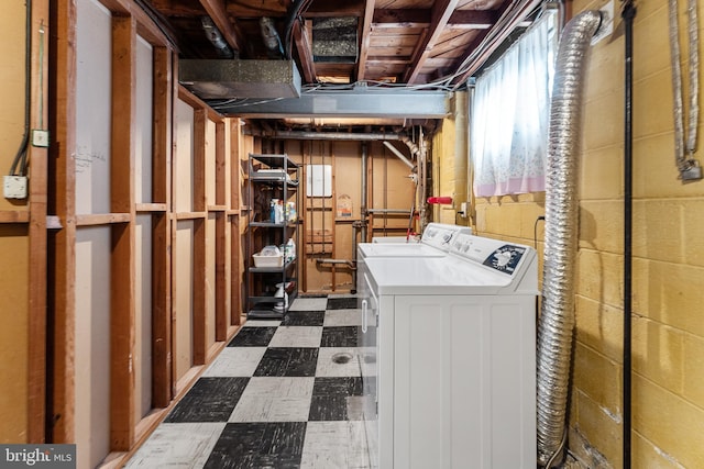 washroom with laundry area, dark floors, and washer and clothes dryer