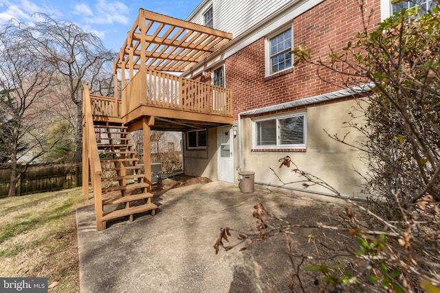 exterior space with fence, a pergola, stairs, a deck, and brick siding