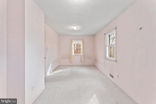 carpeted spare room featuring visible vents