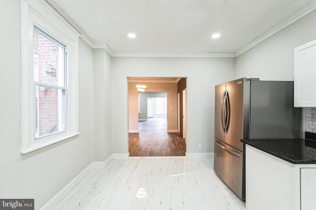 kitchen with baseboards, white cabinetry, freestanding refrigerator, crown molding, and marble finish floor
