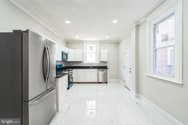 kitchen featuring ornamental molding, white cabinetry, dark countertops, appliances with stainless steel finishes, and marble finish floor