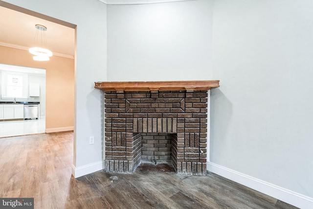interior details with crown molding, a fireplace, wood finished floors, dishwasher, and baseboards