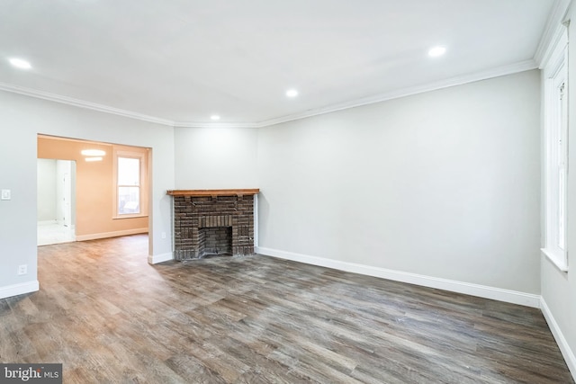 unfurnished living room featuring wood finished floors, baseboards, and ornamental molding