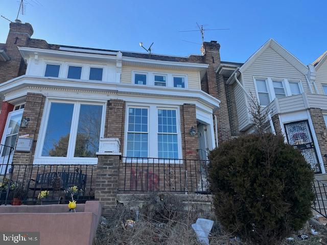 view of front of home with brick siding and a chimney