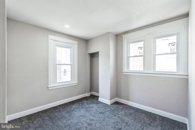 unfurnished bedroom featuring baseboards, recessed lighting, and dark colored carpet