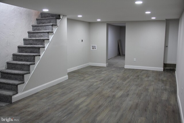 finished below grade area with baseboards, dark wood-style flooring, stairs, and recessed lighting