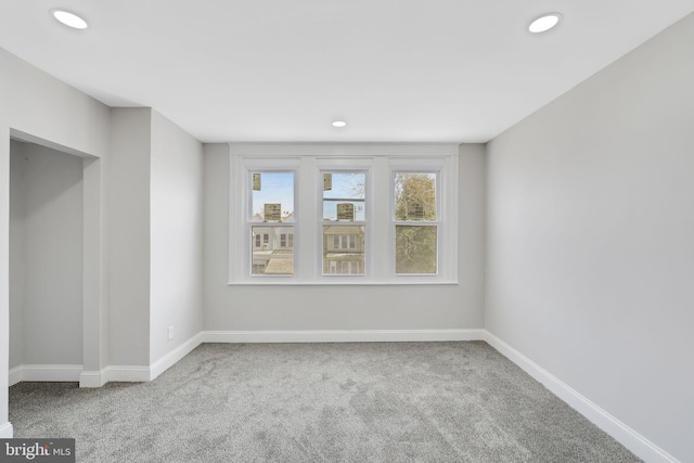 carpeted empty room featuring baseboards and recessed lighting