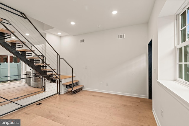 stairs featuring recessed lighting, visible vents, baseboards, and wood finished floors