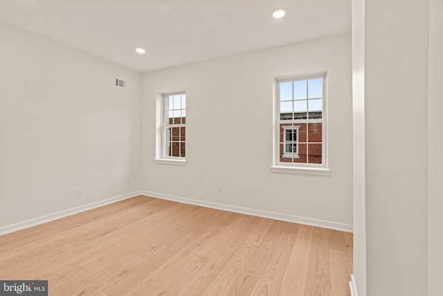 empty room with light wood-style flooring, visible vents, baseboards, and recessed lighting