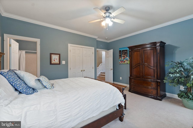 bedroom featuring a closet, light carpet, crown molding, and baseboards