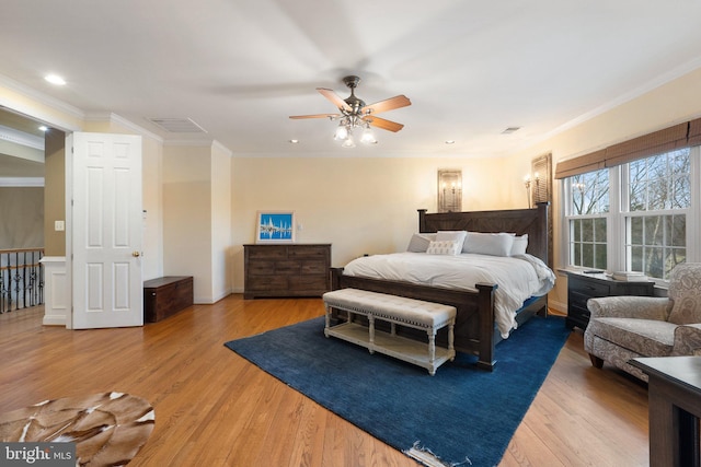 bedroom with visible vents, ornamental molding, and light wood finished floors