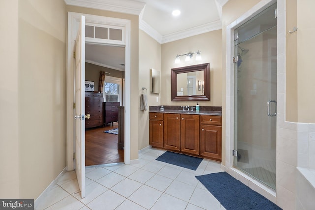 bathroom with vanity, baseboards, tile patterned flooring, a shower stall, and crown molding