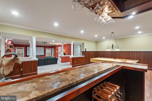 interior space featuring a wainscoted wall, ornate columns, recessed lighting, crown molding, and a dry bar