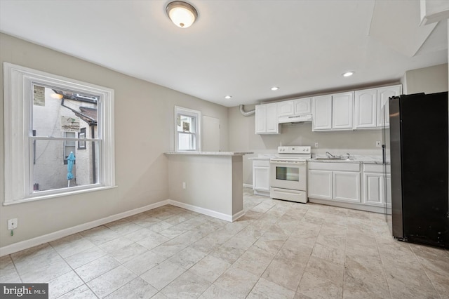 kitchen featuring baseboards, white cabinets, electric stove, freestanding refrigerator, and light countertops