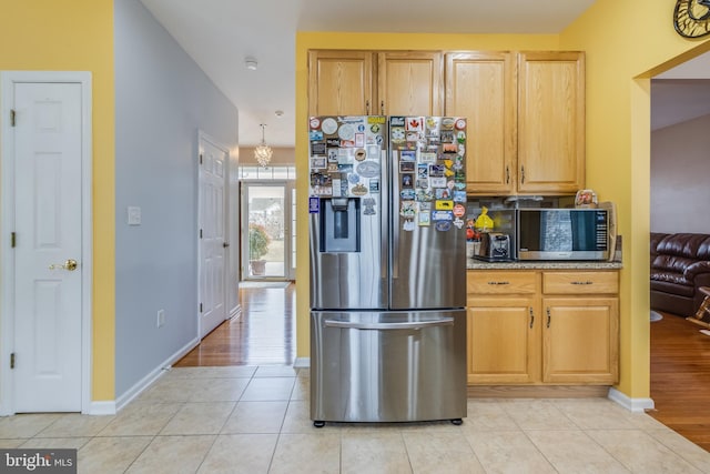 kitchen with stainless steel appliances, light tile patterned flooring, and baseboards