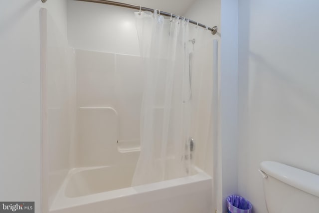 bathroom featuring toilet and shower / bath combo with shower curtain