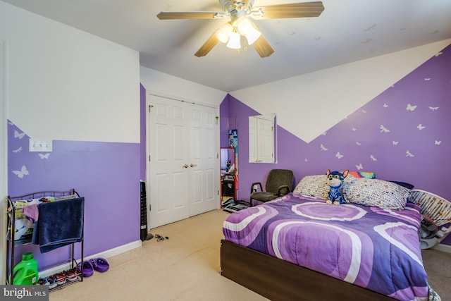 carpeted bedroom with lofted ceiling, a closet, baseboards, and a ceiling fan