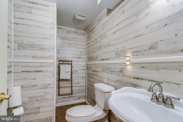 bathroom featuring toilet, visible vents, and a sink